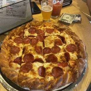a pepperoni pizza and a glass of beer