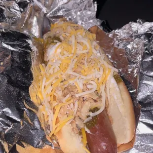 a hot dog covered in cheese and onions