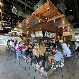 a large group of people sitting at a bar