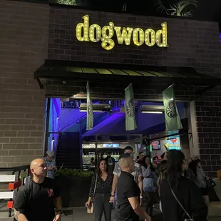 people walking in front of the dogwood