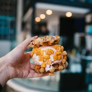 a hand holding a sandwich