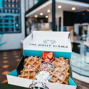 a person holding a box of waffles