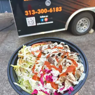 a hand holding a bowl of salad