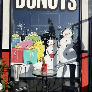 a table and chairs outside a donut shop