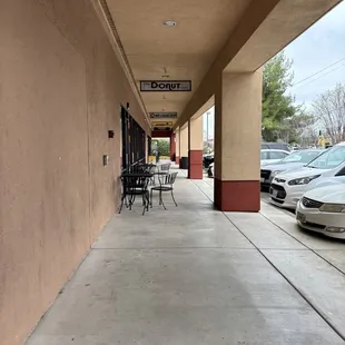 a sidewalk with tables and chairs