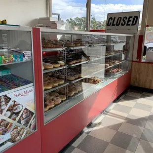 a woman walking past a display of donuts