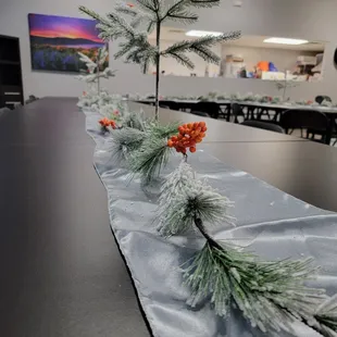 a long table with pine branches and berries