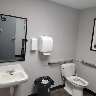a bathroom with a sink, toilet, and trash can