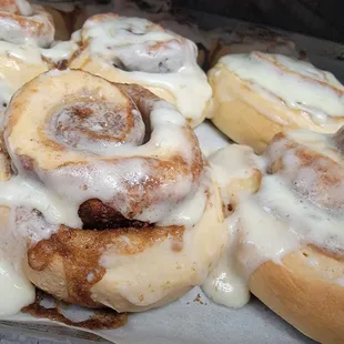a tray of cinnamon rolls with icing