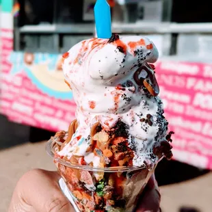a hand holding an ice cream sundae
