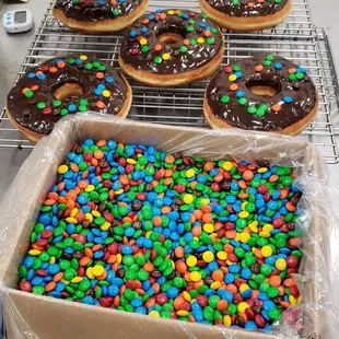 a tray of doughnuts with chocolate frosting and m &amp; m's