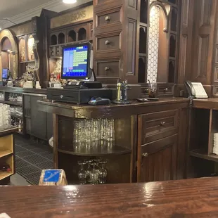 a view of a bar with wine glasses on the counter