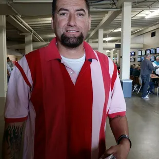 a man in a red and white polo shirt holding a wallet