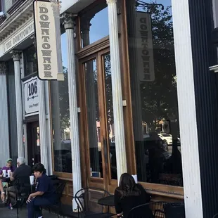 people sitting outside of a restaurant