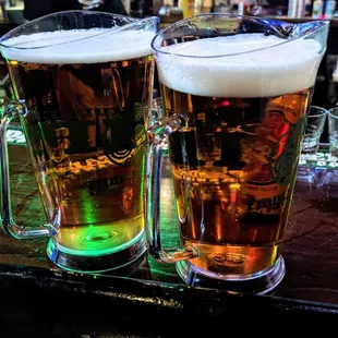 two glasses of beer on a bar