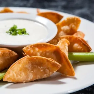 a plate of wontons and celery sticks