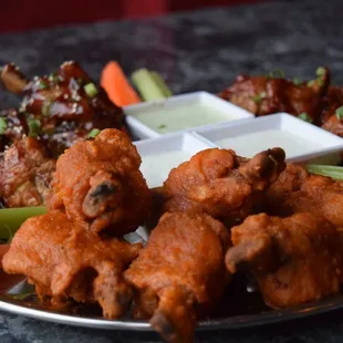 a plate of buffalo wings and carrots