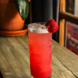 a drink with a strawberry garnish