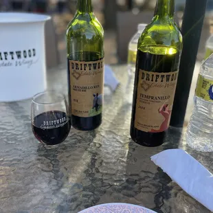a plate of food and two bottles of wine