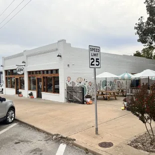 a parking lot with tables and umbrellas