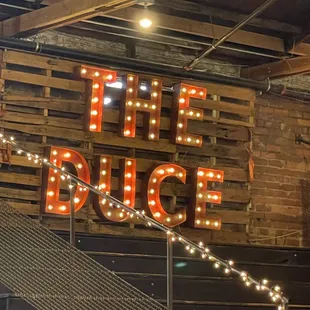 the neon sign above the stairs