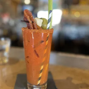 a bloody drink with bacon and pickles