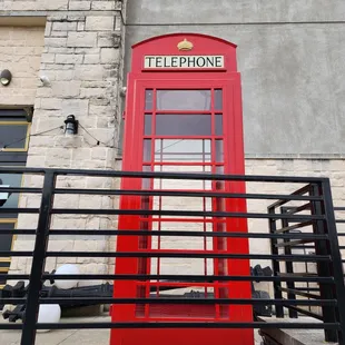 a red telephone booth on the side of a building