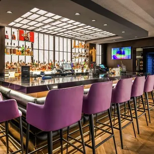 a bar with purple chairs