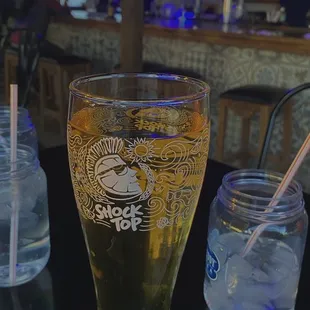 a glass of beer with a straw in it