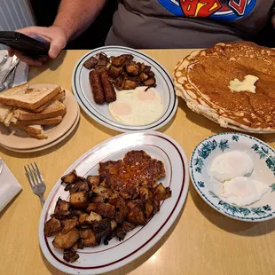 Home fries with onions &amp; peppers, hot sausage patty, poached eggs, a huge pancake, two over easy eggs, breakfast sausage links.