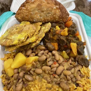 Yellow rice, pinto beans, tostones, beef-less stew and empanada.