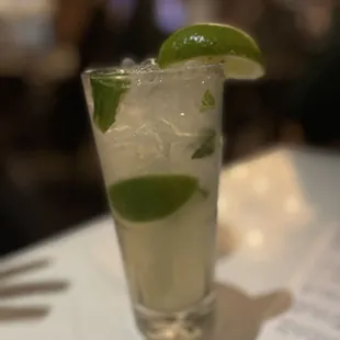 a glass of mojita with a lime garnish
