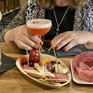 a woman sitting at a table with a plate of food and a drink