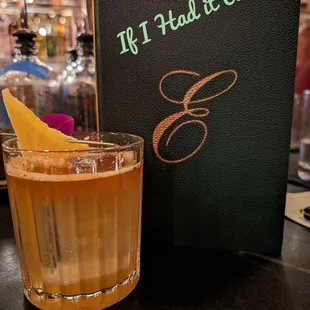 a drink in a glass next to a menu