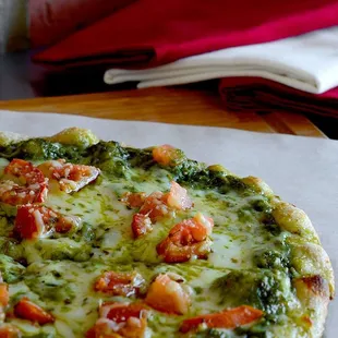 a pizza with tomatoes and spinach