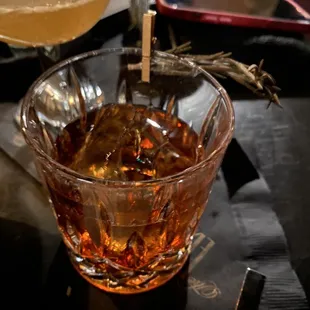 a glass of whiskey and a plate of food