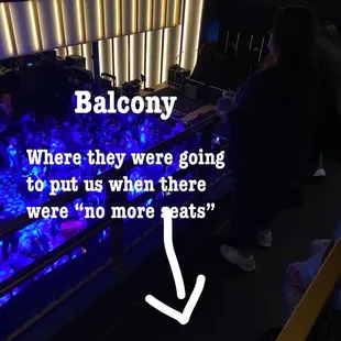 a person standing in front of a bar with a neon sign that says balcony where they were going