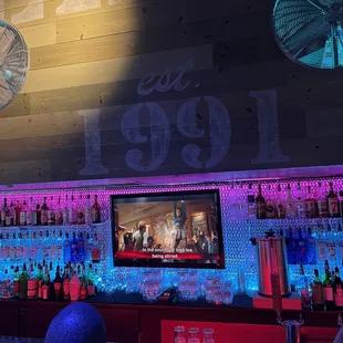 a bar with neon lights and a clock on the wall