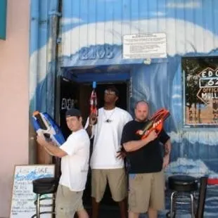 three men standing in front of a building