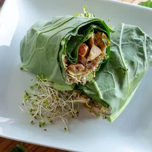 Wrap it Green Seared and seasoned tofu,  tomato, balsamic onions, avocado cream,  sprout mix, zucchini, hummus wrapped in a collard green