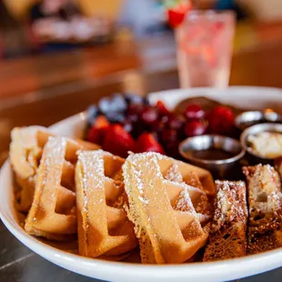 a plate of waffles and fruit