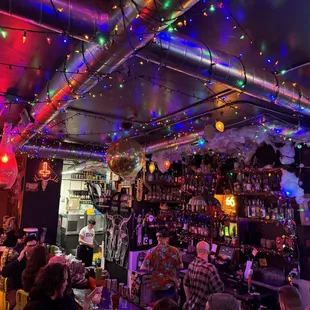 people in a bar with christmas lights