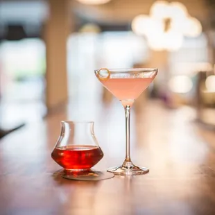 a pink drink and a glass of wine