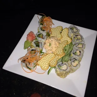a plate of sushi and vegetables