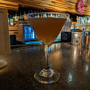 a martini sitting on a bar counter