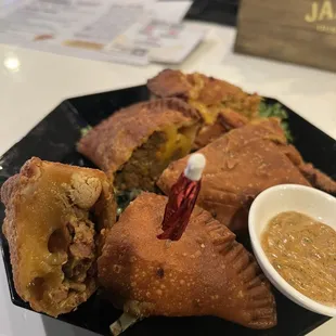 a plate of empanadas with dipping sauce