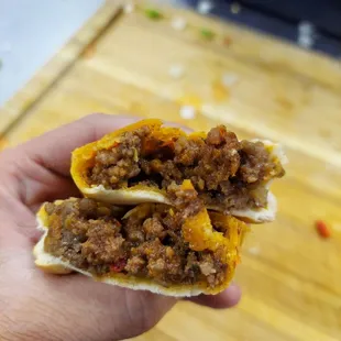 a hand holding a sandwich