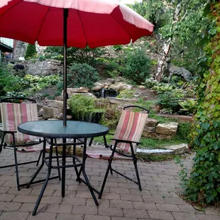 a patio with a table and chairs and an umbrella