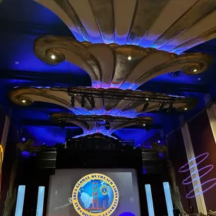 a stage with a podium and a projection screen