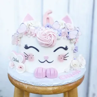 a white cake with pink and purple decorations